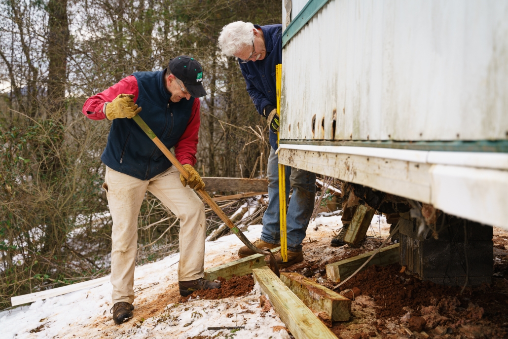 Home Repair Volunteers make repairs to a mobile home's foundation.